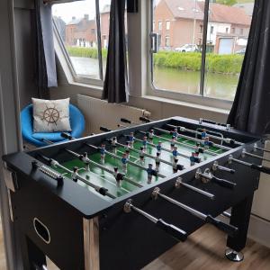a foosball table in a room with windows at Gîte Le Sambre in Thuin