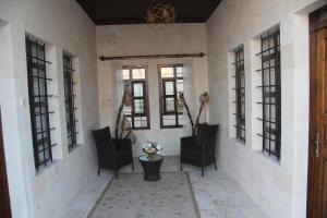 un pasillo con sillas y ventanas negras en HASBAHAN KONUKEVİ&BUTİKOTEL, en Sanlıurfa
