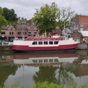 a red and white boat sitting in the water at Gîte Le Sambre in Thuin