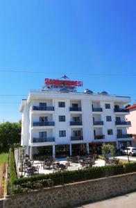 a white hotel with a red sign on top of it at Şahin Tepesi Suite Otel in Trabzon