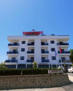 um hotel branco com uma placa em cima em Şahin Tepesi Suite Otel em Trabzon