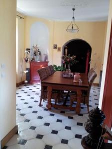 ein Wohnzimmer mit einem Tisch, Stühlen und einem Kamin in der Unterkunft Maison Hôtes Villa Sainte Barbe in Mirecourt