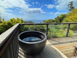 a bath tub sitting on top of a deck at 伊豆稲取テラス-寛道- in Shimoda
