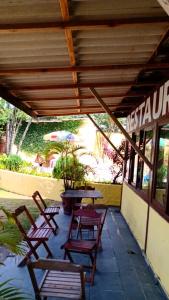 een patio met stoelen, een tafel en een parasol bij Guarujá H Pousada in Guarujá