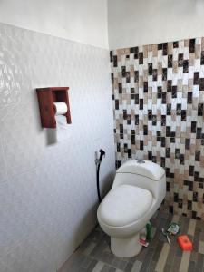 a bathroom with a white toilet in a room at Bogenvil villa in Tanjung