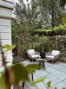 two chairs and a coffee table on a patio at Vakantiehuisje Noé in Gorinchem