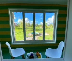 a room with a window with two chairs and a table at Maison D'Hôtes Maison de Campagne Sainte Barbe in Mirecourt
