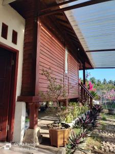 a porch of a house with a wooden wall at Bogenvil villa in Tanjung