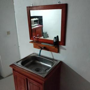 a sink in a bathroom with a mirror above it at Bogenvil villa in Tanjung