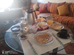 una mesa de centro con alimentos para el desayuno y bebidas. en DAR SARSAR airport, en Marrakech