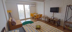 ein Wohnzimmer mit einem TV und einem Tisch mit Stühlen in der Unterkunft Krkulj Apartments in Ohrid