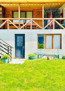 ein Haus mit einer blauen Tür und einer Veranda in der Unterkunft House in Mestia Mood of silence svaneti in Lagami