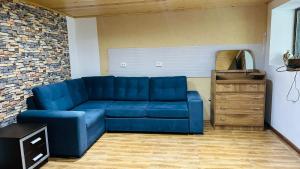 ein blaues Sofa im Wohnzimmer mit Ziegelwand in der Unterkunft House in Mestia Mood of silence svaneti in Lagami