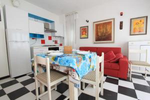 a kitchen with a table and a red couch at Eco del Mare Apartments in Lido di Pomposa