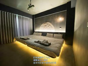 a bedroom with a large bed with a lightedigunigunigunigun at 月出悠悠Moon Rise未與阿勾達合作電聯付訂才算預訂完成 in Hengchun South Gate