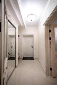 un couloir avec une porte blanche et un miroir dans l'établissement Apartments U Ratushi, à Kamianets-Podilsky