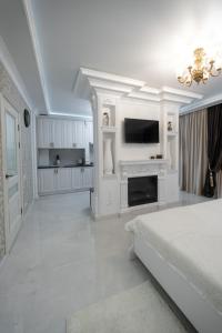 a white bedroom with a bed and a fireplace at Apartments U Ratushi in Kamianets-Podilskyi