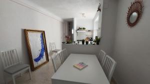 uma sala de jantar com uma mesa, cadeiras e um espelho em La Casa del Bienestar em Cabra