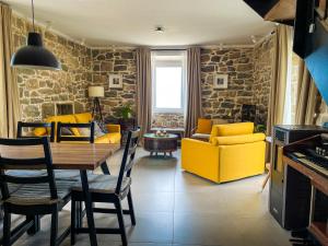 a living room with a table and yellow chairs at Old stone house Klarić in Brela