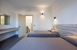 普拉亞戴爾雷安格萊斯的住宿－Smartr Maspalomas Corinto，酒店客房,设有两张床和镜子