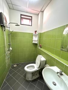 La salle de bains est pourvue de carrelage vert, de toilettes et d'un lavabo. dans l'établissement Home One Love Ayutthaya main Zone by Baan one love group, à Phra Nakhon Si Ayutthaya