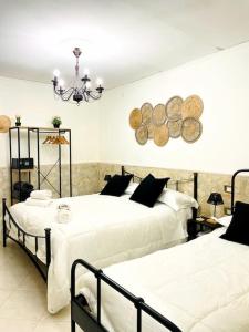 1 dormitorio con 2 camas y lámpara de araña en Casa Vacanza Gentileschi - Self Check-in, en Nápoles
