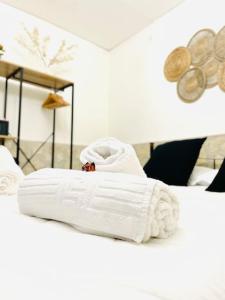una pila de toallas blancas sentadas encima de una cama en Casa Vacanza Gentileschi - Self Check-in, en Nápoles