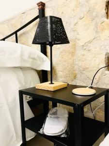 una mesa negra con una lámpara junto a una cama en Casa Vacanza Gentileschi - Self Check-in, en Nápoles