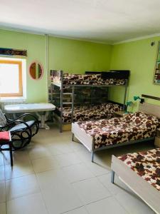 a bedroom with two beds and a table and a desk at Lovely Goris in Goris