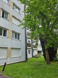 un edificio de apartamentos con un árbol delante de él en chambre 5mn de paris, en Fontenay-sous-Bois