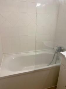 a white bath tub with a glass shower door at Bandol A Bandol cha cha cha in Bandol