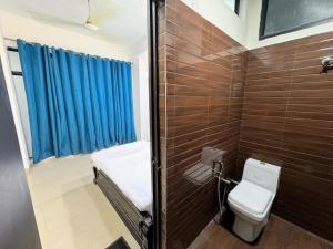 a bathroom with a toilet and a blue curtain at Backpacker's Nest in Amritsar