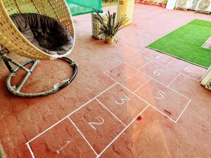a wicker chair sitting on a tiled floor with words on it at Backpacker's Nest in Amritsar