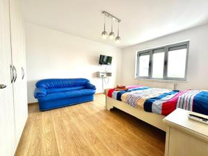 a bedroom with a bed and a blue couch at Aky&Suki Sea View Apartments in Olimp +70 photos