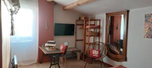 um quarto com uma mesa e cadeiras e um espelho em L'OAZIS em Malissard
