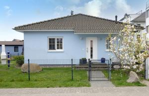 a blue house with a fence in front of it at FH Das blaue Haus am Peenestrom in Peenemünde