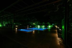 an empty pool at night with green lights at Veerdency Luxury resort in Bangalore