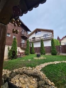 una casa con un patio con un camino de piedra delante de ella en Vila Șoimul Predeal en Predeal