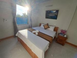 a bedroom with a large bed and a window at Bee Backpackers Hostel in Quang Binh +40 photos