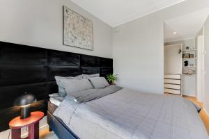 a bedroom with a large bed with a black headboard at 15 korruse premium katusekorter in Tallinn