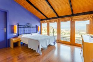 - une chambre avec un lit aux murs bleus et des fenêtres dans l'établissement Hotel Alda Triskel, à Sos del Rey Católico