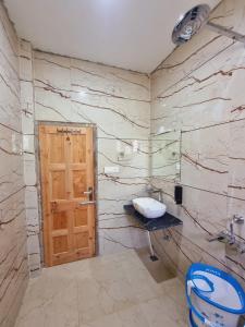 La salle de bains est pourvue de toilettes et d'une porte en bois. dans l'établissement The Frost Heaven - Dalhousie, à Dalhousie