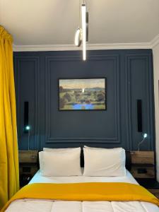 卡薩布蘭卡的住宿－The Hotel Syracuse，一间卧室拥有蓝色的墙壁,配有一张带两个枕头的床