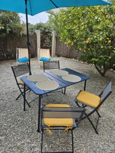 a blue table with chairs and an umbrella at Studio calme avec jardin in Canet-en-Roussillon