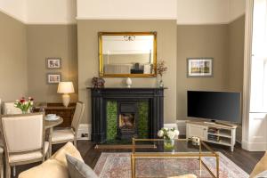 ein Wohnzimmer mit einem Kamin und einem Spiegel in der Unterkunft Elizabeth House 1 - By Luxury Apartments in Cheltenham