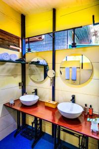 two sinks in a bathroom with two mirrors at Waraka - Udawalawe by Thema Collection in Udawalawe