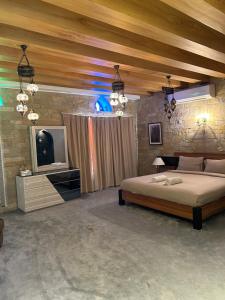 um quarto com uma cama grande e uma televisão em Valley Guest Home em Nizwa