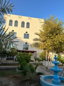 a building with a blue fountain in front of it at Valley Guest Home in Nizwa