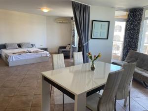 ein Wohnzimmer mit einem Tisch und einem Bett in der Unterkunft Midia SP Apartments in Aheloy