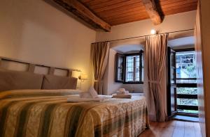 a bedroom with a bed and a large window at Dimora Storica Casa Vanni in Villadossola